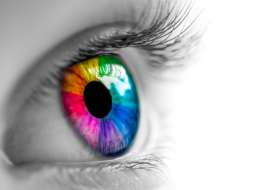 foto em preto e branco de olho com íris no espectro do arco-íris para ilustrar artigo sobre ceratopigmentação